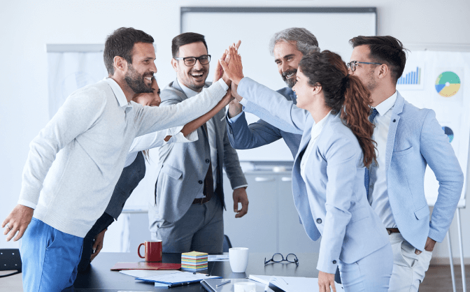 Fusiones y adquisiciones Foto de un equipo de trabajo celebrando el proyecto de fusiones y adquisiciones de banca de inversión.
